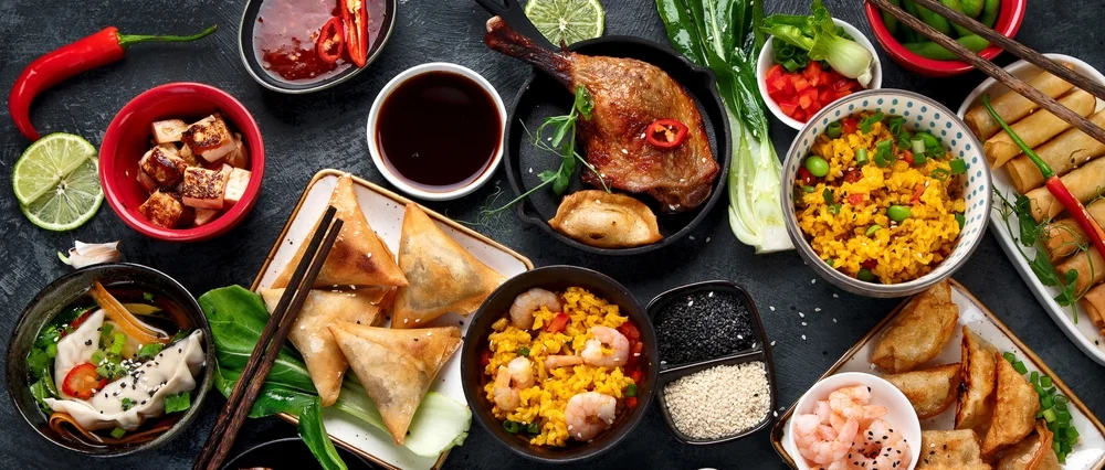 Variety of Chinese dishes and snacks on a dark gray background