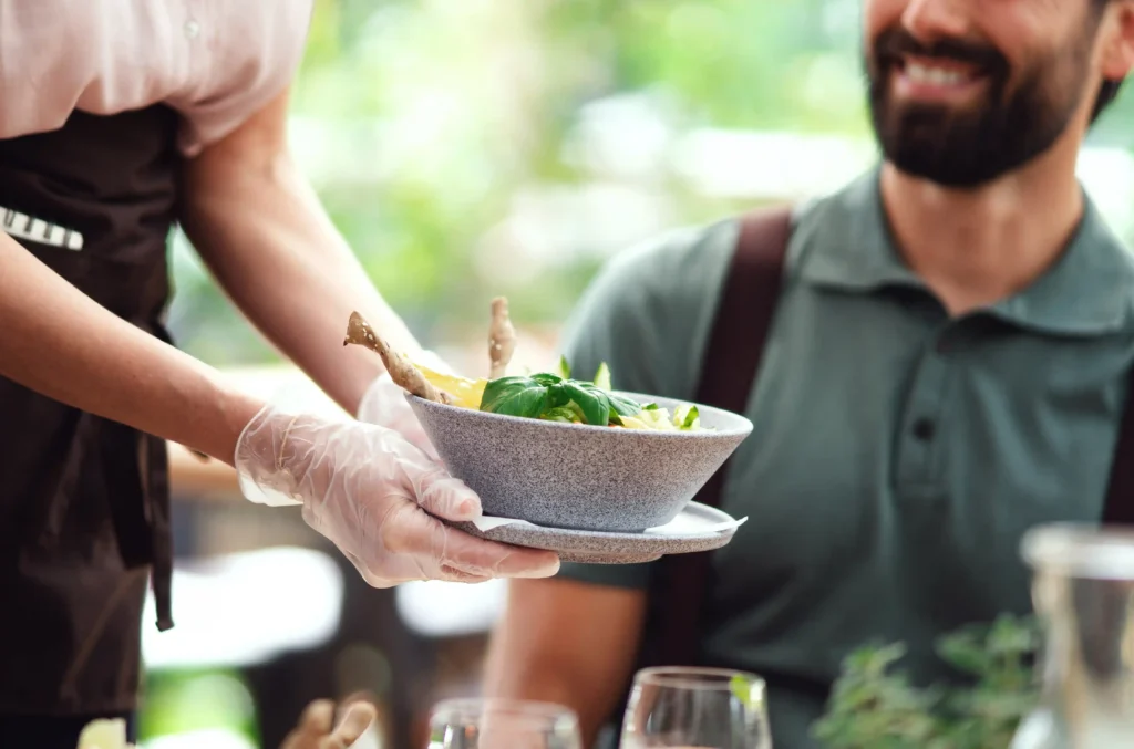 Person Serving Green Curry in Thai Restaurant