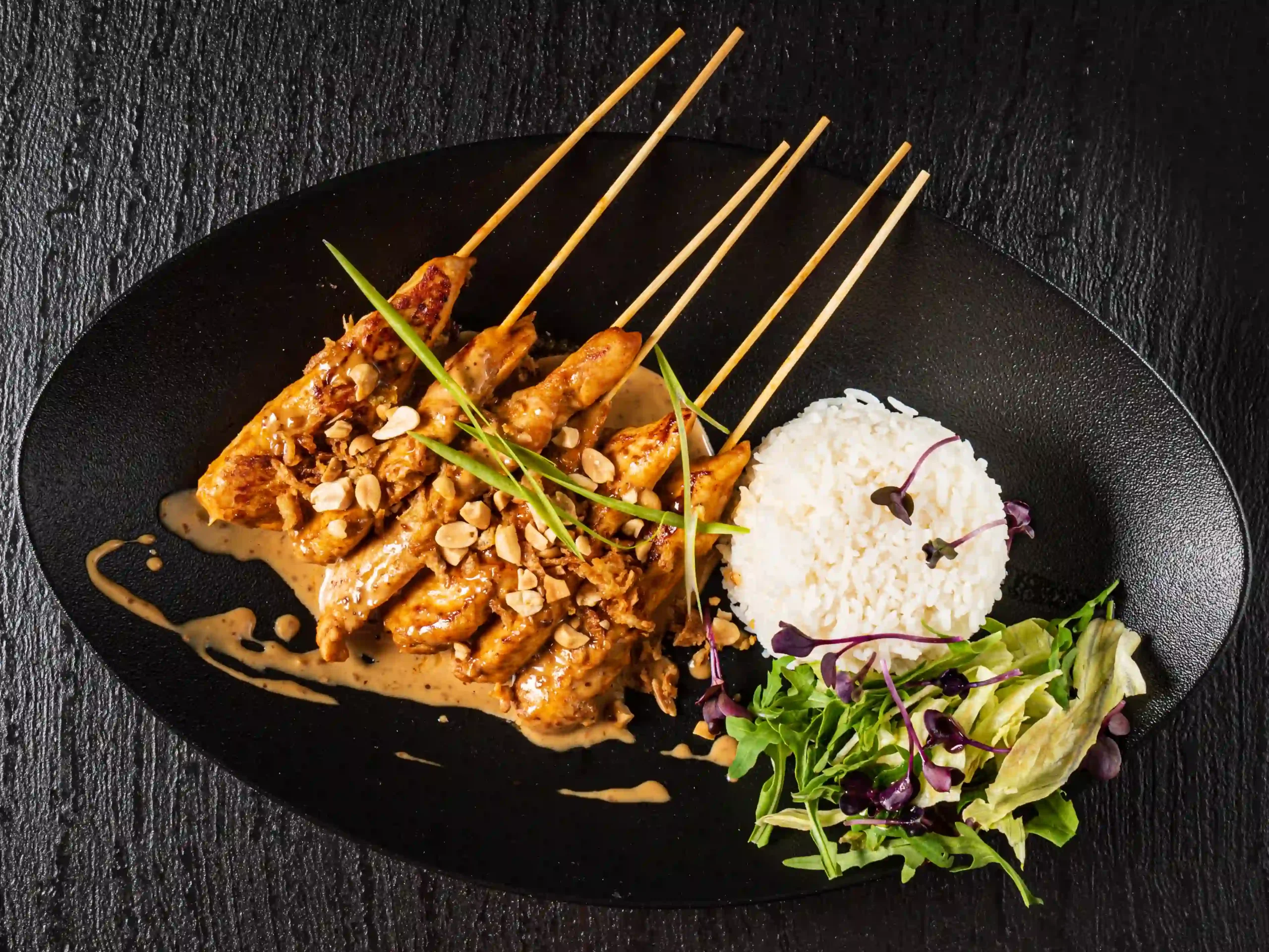 Chicken satay skewers served with creamy peanut sauce and rice