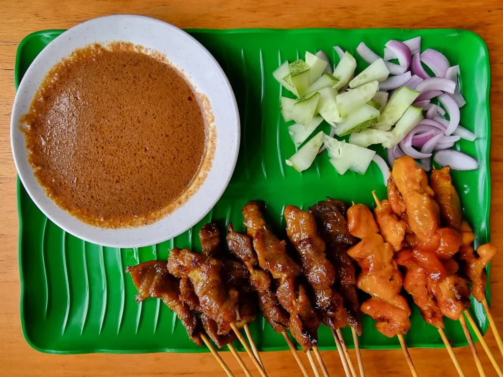 Different variations of Chicken Satay with Peanut Sauce and Vegetables