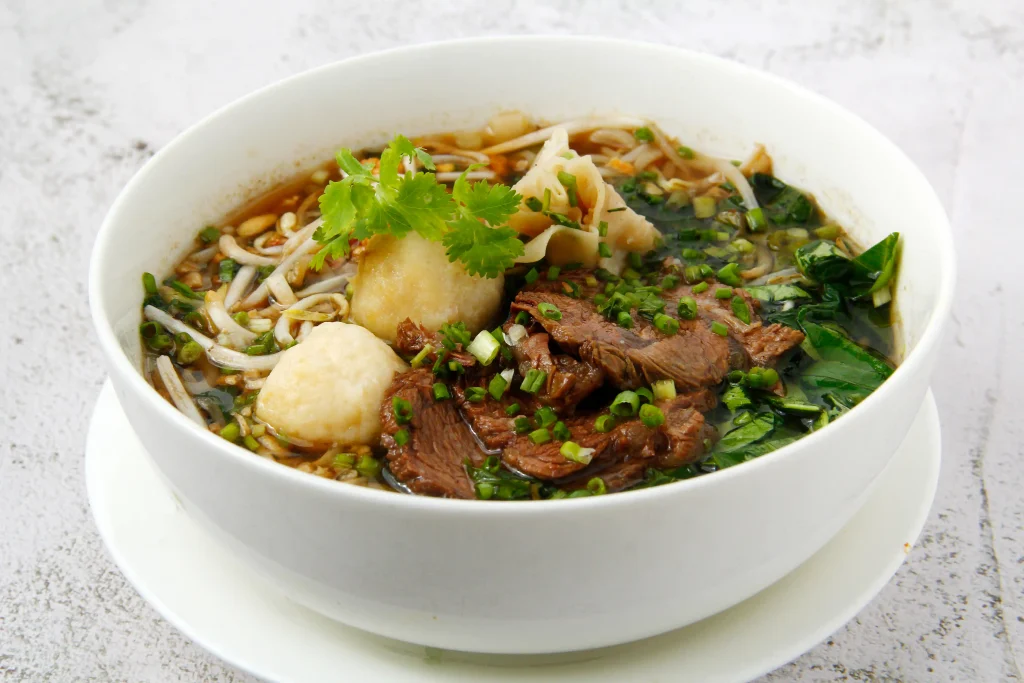 Bowl of delicious Thai Boat Noodles with meat.