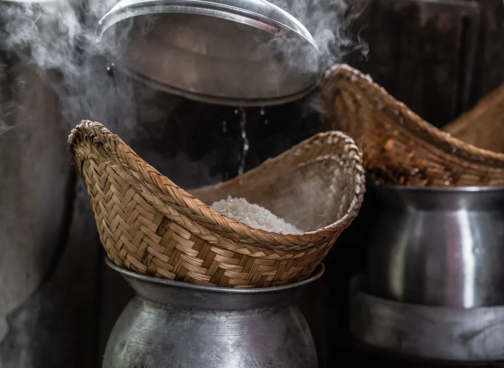 Steaming Rice Cooked in Traditional Woven Basket